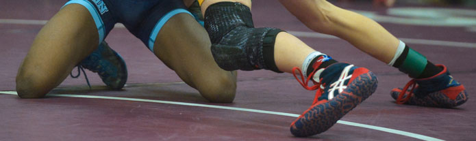 two wrestlers sparring while wearing wrestling shoes